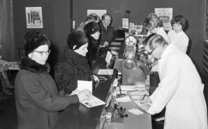 Historiakuva apteekista vuodelta 1965. Farmaseutit palvelevat asiakkaita oululaisessa apteekissa helmikuussa 1965.
